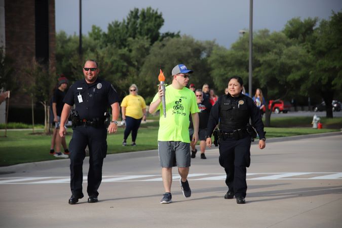 Special Olympics participant holding the Olympic torch.